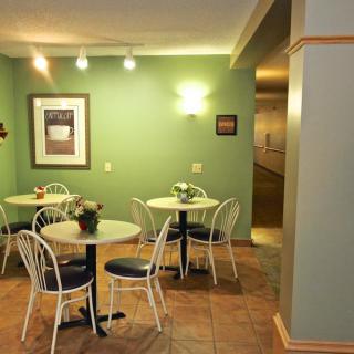 Cozy cafe interior with green walls and seating area.
