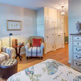 A cozy bedroom with floral patterns and comfortable seating.