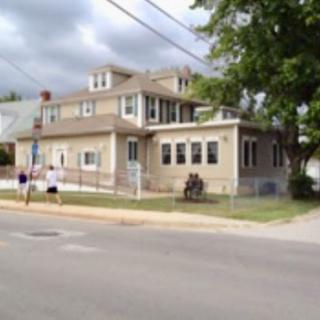 A two-story residential house with a front porch and a view of the street.