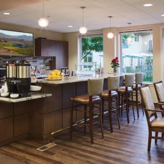 A modern kitchen with a bar area, featuring comfortable seating and stylish lighting.