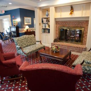 A cozy living room with a brick fireplace, comfortable seating, and a coffee table.