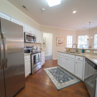 A modern kitchen with stainless steel appliances and white cabinetry.
