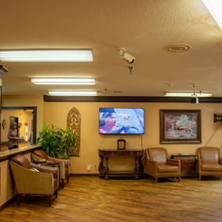 A cozy waiting area featuring comfortable seating, a television, and decorative elements.
