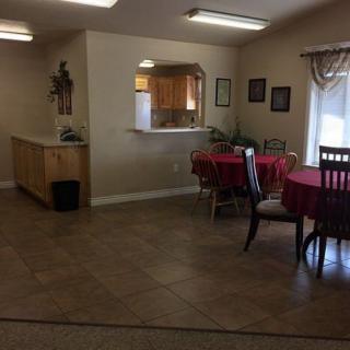 A cozy dining area with tables and chairs near an open kitchen.
