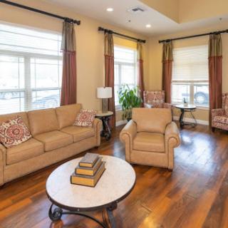 A cozy living room featuring a comfortable sofa, armchairs, and a stylish coffee table, illuminated by natural light.