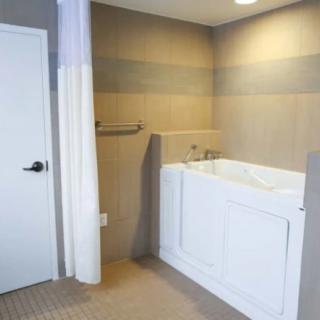 A modern bathroom featuring a walk-in bathtub designed for accessibility.