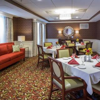 A warmly decorated dining room with neatly set tables and comfortable seating.