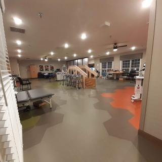 A spacious, well-lit gym featuring exercise equipment and treadmills.