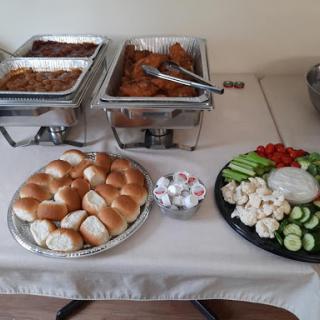A delicious spread featuring a variety of dishes, bread rolls, and fresh vegetables.