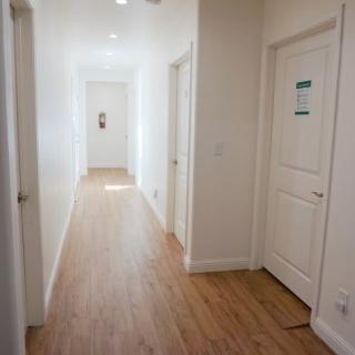 A bright and modern hallway with wooden floors and several doors.