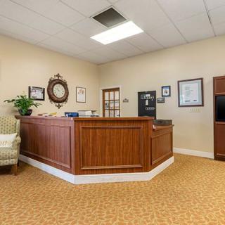A neat and tidy reception area with a wooden desk and comfortable seating.