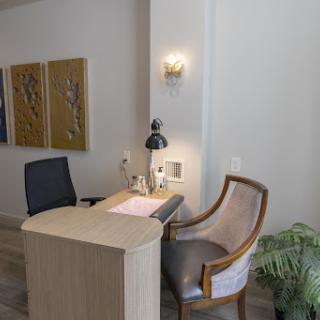 A modern reception area featuring a sleek desk, comfortable seating, and artistic wall decor.