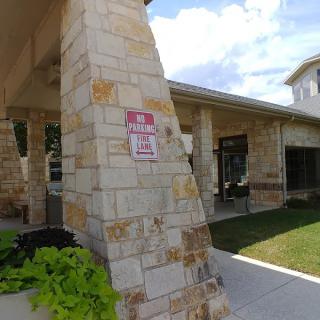 A stone building entrance with a sign indicating parking information.