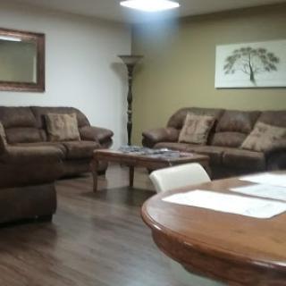 A cozy living room featuring comfortable sofas and a wooden table.