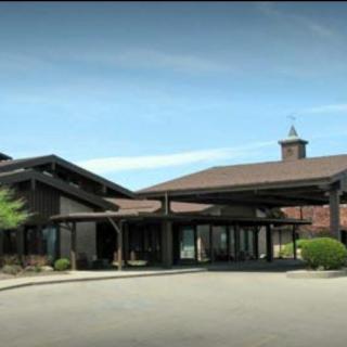 A modern building with a prominent entrance under a clear blue sky.