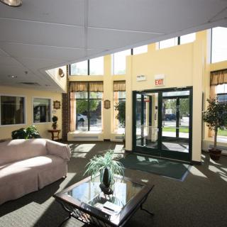 A bright and inviting lobby area with large windows, a glass door entrance, and comfortable seating.