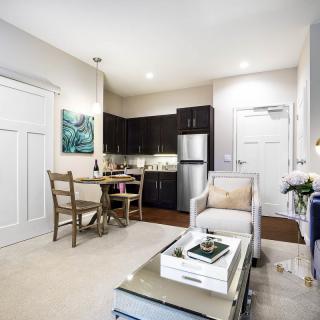 A modern and cozy apartment featuring a compact living room and kitchen area with stylish decor.