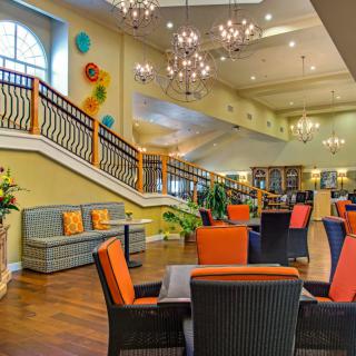 A vibrant and modern lounge area with colorful seating and elegant chandeliers.