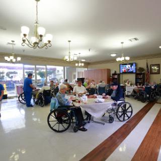 Residents enjoy a social meal in a comfortable nursing home setting.