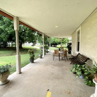 A cozy porch with outdoor furniture and plants, perfect for relaxation.