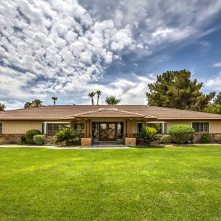 A suburban house with a well-maintained lawn under a cloudy sky.