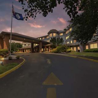 A grand building entrance with a flag at sunset.