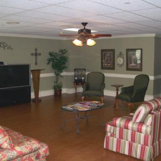 A cozy living room area featuring comfortable chairs and a ceiling fan, perfect for relaxation.
