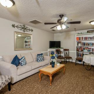 A cozy living room with comfortable seating, a coffee table, and a well-stocked bookshelf.