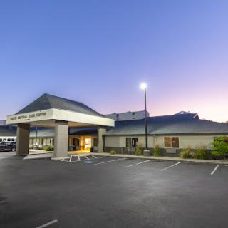 A modern commercial building captured at dusk, highlighting its architecture and surrounding parking lot.