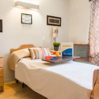 A cozy bedroom with a neatly made bed, stylish decor, and natural lighting.