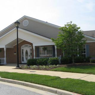 A suburban house with a well-maintained lawn and a lamp post in front.