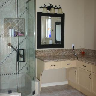 A modern bathroom with a glass shower enclosure and a vanity area.