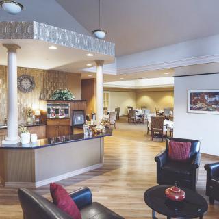A spacious and elegantly decorated reception area with comfortable seating and decorative columns.