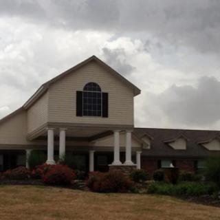 A large residential building under a cloudy sky with landscaped surroundings.