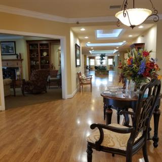 A spacious and well-lit hallway featuring elegant furniture and decorative elements.