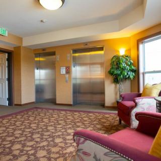 A cozy elevator lobby with comfortable seating and warm lighting.