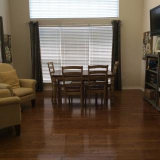 A cozy living and dining area with wooden flooring and neutral decor.