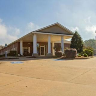 A building with a grand entrance featuring columns and surrounding landscaping.