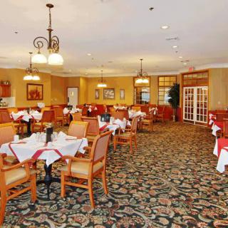 A spacious and elegantly decorated restaurant dining room with neatly arranged tables and chairs.