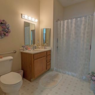 A cozy bathroom with a vanity, mirror, and a shower area.