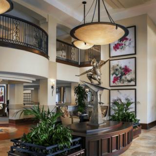 A luxurious lobby featuring elegant lighting, a central statue, and vibrant artwork.