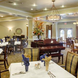 An elegant dining area with neatly arranged tables and a chandelier, creating a formal atmosphere.