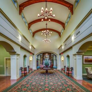 A grand hallway featuring chandeliers and traditional architectural details.