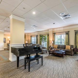 A spacious lobby featuring a grand piano and comfortable seating areas.
