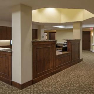 A well-designed office reception area with wood paneling and carpeted floor.
