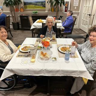 Three friends enjoying a meal together in a cozy dining setting.