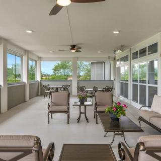 A spacious covered patio with comfortable outdoor seating and ceiling fans.