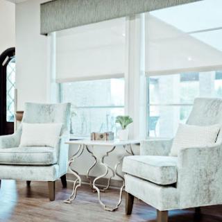 A cozy living room setup featuring two elegant chairs and a stylish side table, bathed in natural light.