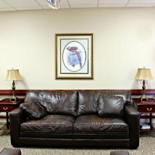 A cozy living room with a leather sofa and framed artwork on the wall.