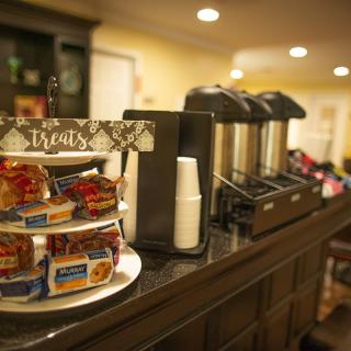A coffee station in a hotel lobby featuring snacks and refreshments.